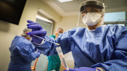 Hadassah Ein Kerem medical team members, wearing protective gear, are handling a Coronavirus test sample of Hadassah Ein Kerem workers at the Hadassah Ein Kerem Hospital in Jerusalem on March 24, 2020. Photo by Yossi Zamir/Flash90 *** Local Caption *** קורונה
וירוס
מגיפה
מגן דוד אדום
צוות רפואי
הצלה
בדיקות
נשאים
הדסה עין כרם